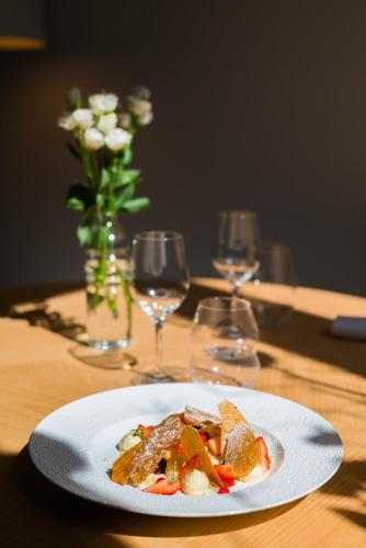 a plate of food on a table with wine glasses at La Citadelle Hotel Metz - MGallery Collection in Metz