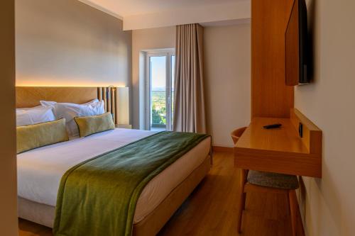 una stanza d'albergo con un letto e una finestra di Santa Eufémia Covilhã Hotel a Covilhã