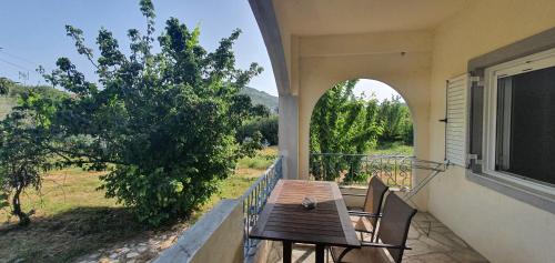 patio con mesa y sillas en el balcón en Eleni Karouti rooms for rent, en Pteleós