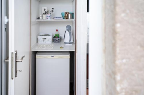 uma pequena cozinha com um armário branco e comodidades para preparar café em Viola rooms em Gruda