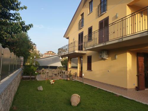 een achtertuin van een gebouw met een tuin met rotsen in het gras bij B&B Villa Chiara Bed and Breakfast in Taormina