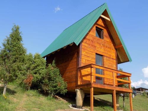 a large wooden house with a green roof at Avlija Biberović in Sjenica