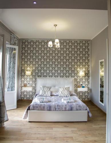 a bedroom with a large bed and two lights at Home Syrakos in Syracuse