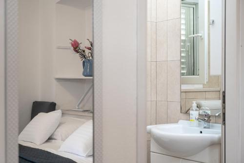 a white bathroom with a sink and a mirror at Viola rooms in Gruda