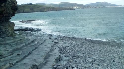 a rocky beach next to the ocean at Hotel Palacio Muñatones in Muskiz