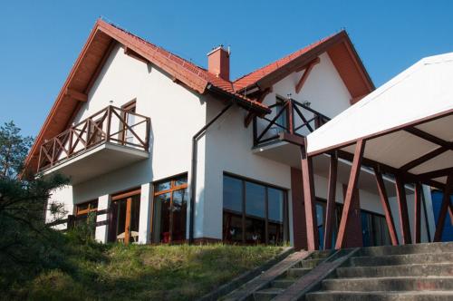a white building with stairs in front of it at Willa Zanzibar na Wydmie in Sztutowo