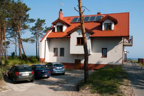 una casa con coches aparcados en un estacionamiento en Willa na Wydmie-pokoje z widokiem na morze, en Sztutowo