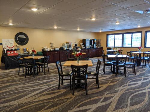 a dining room with tables and chairs and a cafeteria at Cobblestone Inn & Suites - Merrill in Merrill