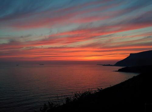 a sunset over a body of water with the sky at Hotel Palacio Muñatones in Muskiz
