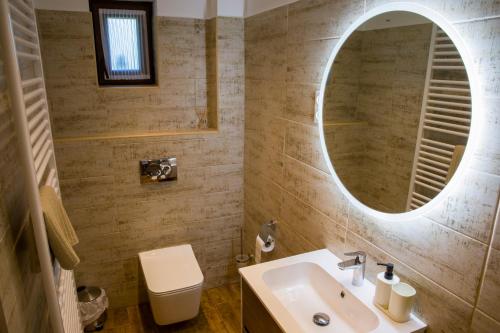 a bathroom with a sink and a mirror at Kukorica Csárda Apartman in Balatonújlak