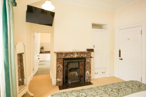 a living room with a fireplace and a tv at Springkell in Eaglesfield