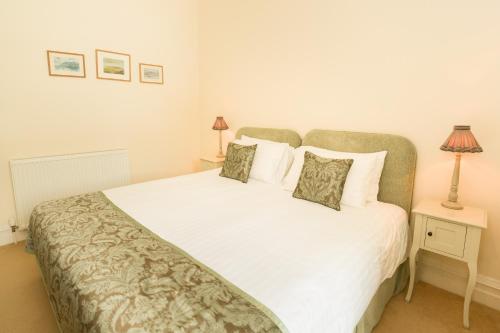a bedroom with a large white bed with two pillows at Springkell in Eaglesfield
