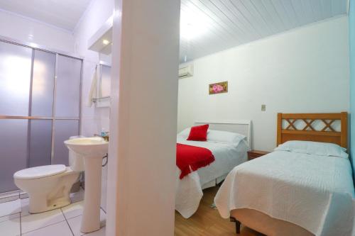 una camera con letto, servizi igienici e lavandino di Pousada Tia Eni a Gramado
