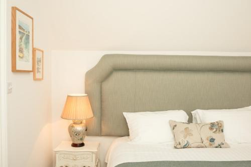 a bedroom with a bed and a lamp on a night stand at Springkell in Eaglesfield