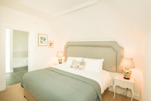 a bedroom with a large bed with two lamps at Springkell in Eaglesfield