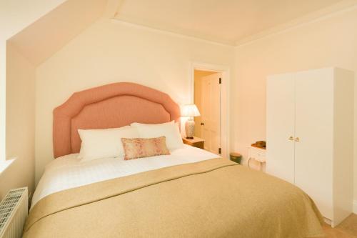 a bedroom with a large bed with a large headboard at Springkell in Eaglesfield