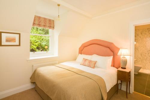 a bedroom with a large bed and a window at Springkell in Eaglesfield