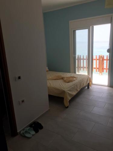 a bedroom with a bed and a door to a balcony at Villa John in Borsh