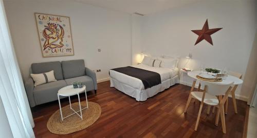 a bedroom with a bed and a couch and a table at Alameda11 in Cádiz