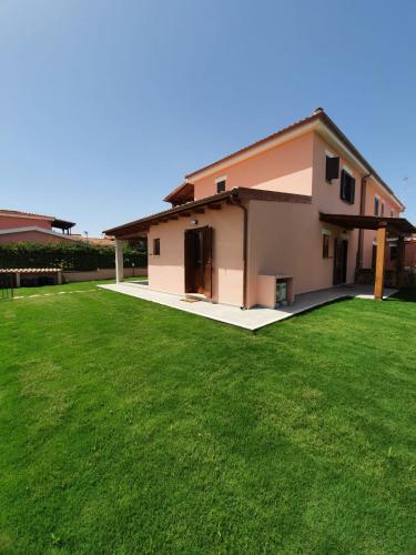 a house with a green lawn in front of it at Affittacamere Samar in San Teodoro