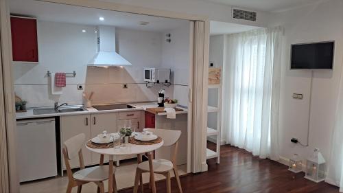 a kitchen with a table and chairs and a sink at Alameda11 in Cádiz