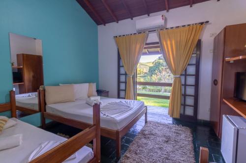 a room with two beds and a window at Hotel Fazenda Pintado na Brasa in Guararema