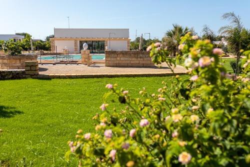 einen Busch mit rosa Blumen vor einem Pool in der Unterkunft STELLA MARINA B&B in Alliste