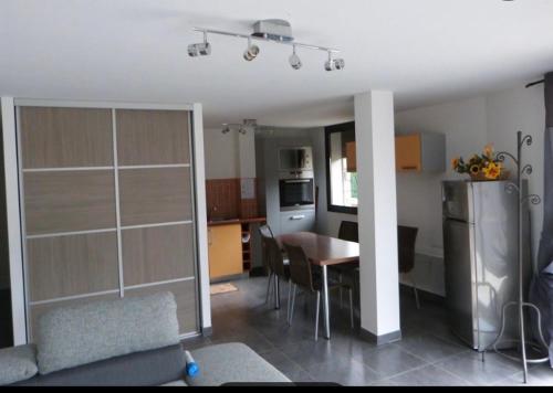 Il comprend un salon et une cuisine avec une table et un réfrigérateur. dans l'établissement Appartement spacieux 3 chambres, à Génos