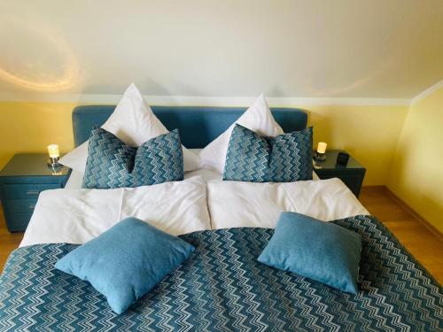 ein Bett mit zwei blauen Kissen darüber in der Unterkunft Ferienwohnung Heide in Freudenstadt