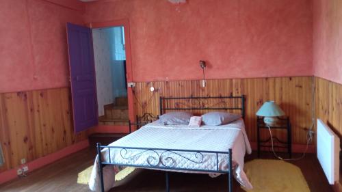 een slaapkamer met een bed in een kamer met rode muren bij Les deux Licornes in Anchenoncourt-et-Chazel