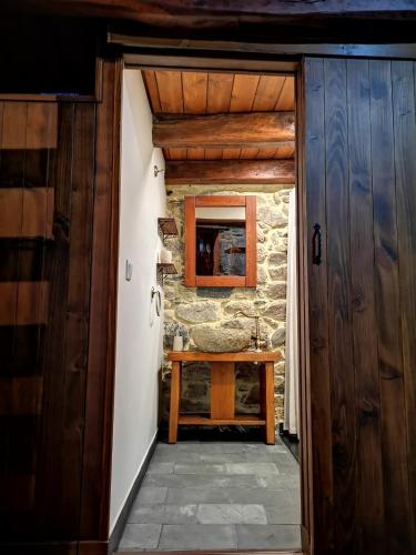 a door leading into a room with a stone wall at El Cuarto in Suarbol