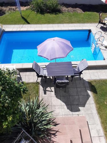 a table with an umbrella next to a swimming pool at Appartment Andrea in Eugendorf