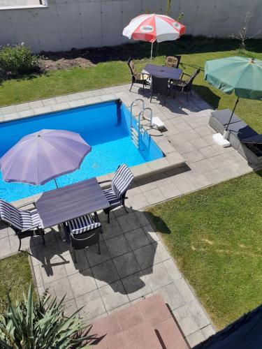 a pool with tables and umbrellas and a table and chairs at Appartment Andrea in Eugendorf