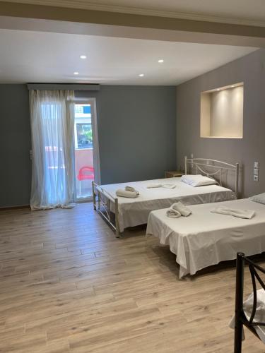 a room with two beds and a window at Studios Artemis in Lefkada Town