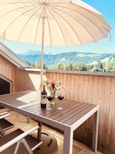 a table with two glasses of wine and an umbrella at Rosenhaus 2 in Schwarzenberg im Bregenzerwald