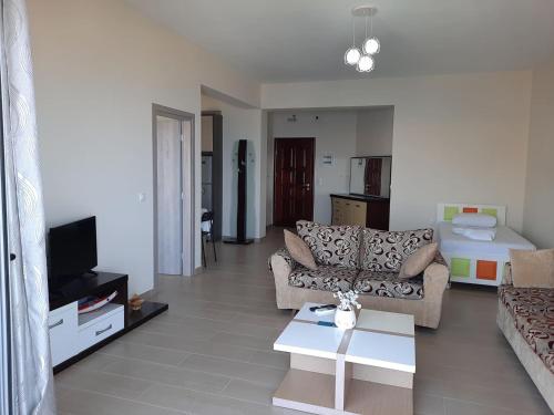 a living room with a couch and a tv at Bill's Apartments in Sarandë