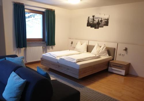 um quarto com uma cama e um sofá em Gasthof Waldruhe em Solda