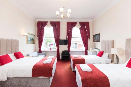 a hotel room with two beds and red carpet at Edinburgh Rays Guest House in Edinburgh