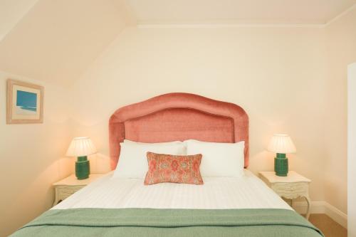 a bedroom with a white bed with a red pillow at Springkell in Eaglesfield