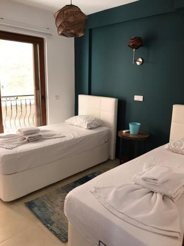 2 camas en una habitación con una pared azul en Kasinn Apart Beyaz, en Kas