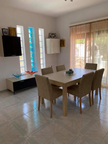 a dining room with a table and chairs and a television at Villa George in Apolakkiá