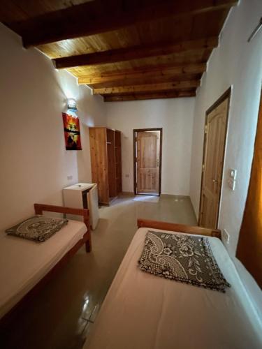 a bedroom with two beds in a room with wooden ceilings at Dolphin Camp in Dahab