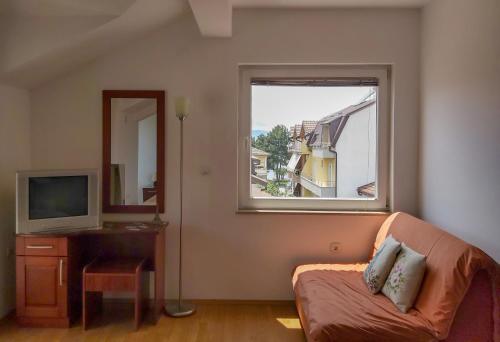sala de estar con sofá y ventana en Celus Apartments Ohrid, en Ohrid