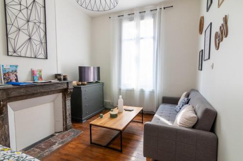 un salon avec un canapé et une cheminée dans l'établissement Little GAMBETTA, à Saumur