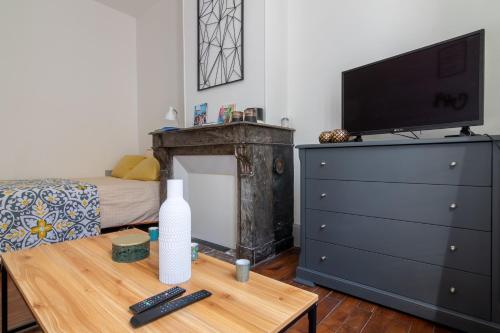 a room with a dresser and a table with a television at Little GAMBETTA in Saumur