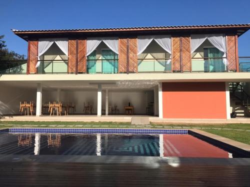 a house with a swimming pool in front of it at Foca Guest House in Búzios