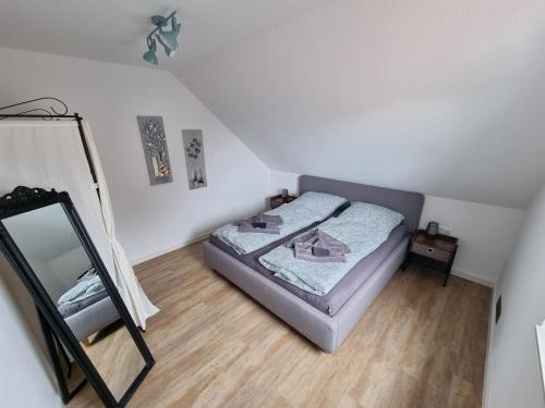 een kleine slaapkamer met een bed en een spiegel bij Frischer Wind in Neuharlingersiel