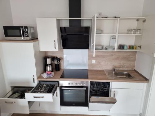 een keuken met witte kasten en een fornuis met oven bij Frischer Wind in Neuharlingersiel
