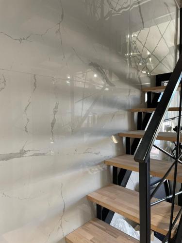 a white marble wall with a staircase in a room at Apartman Plaža Lux in Veliko Gradište