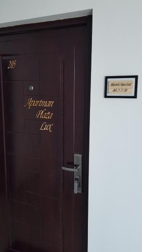 a wooden door with a sign on top of it at Apartman Plaža Lux in Veliko Gradište